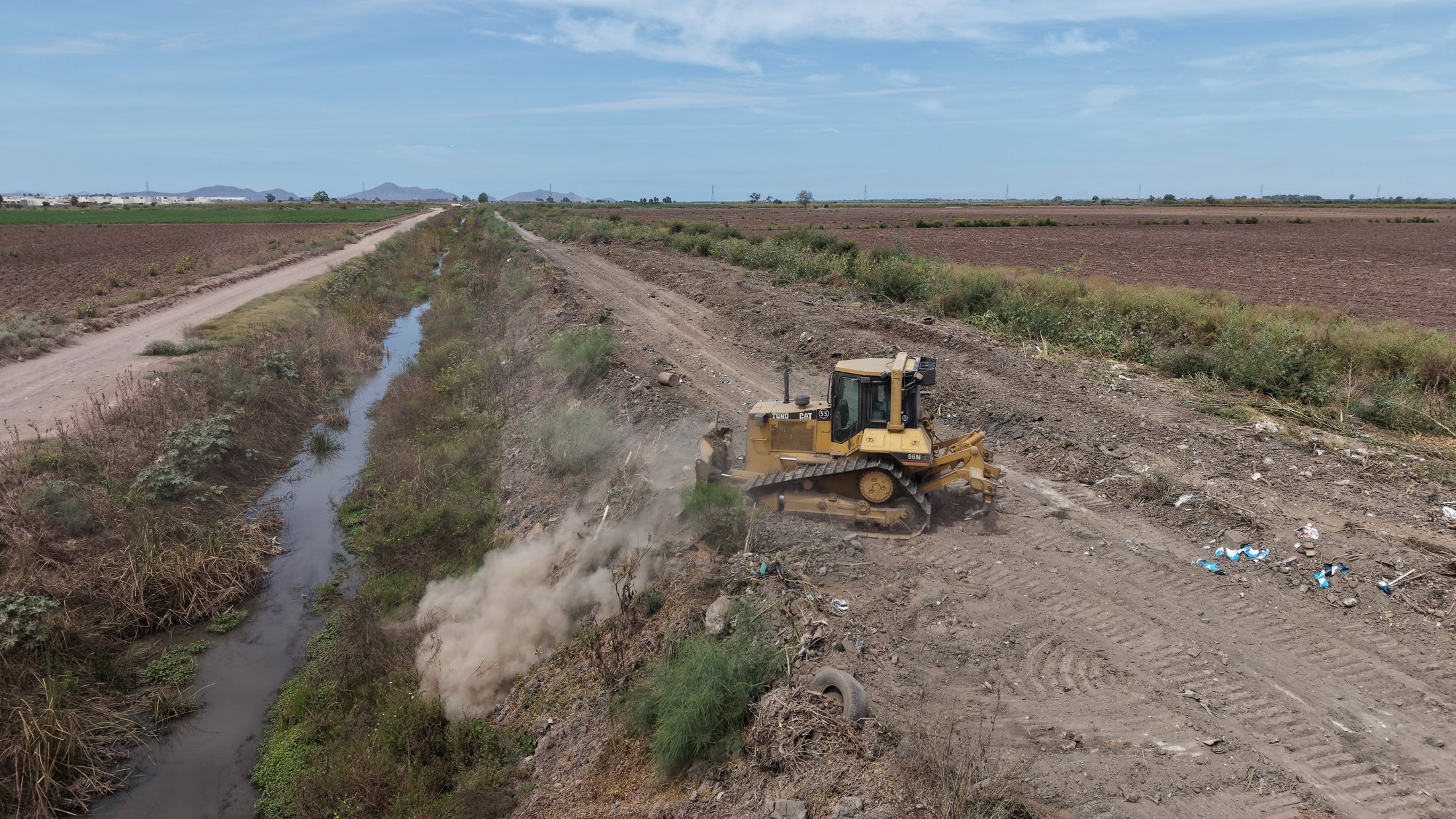 Toma aérea de campo abierto con maquinaria sobre el bordo operativo, mayo de 2026.