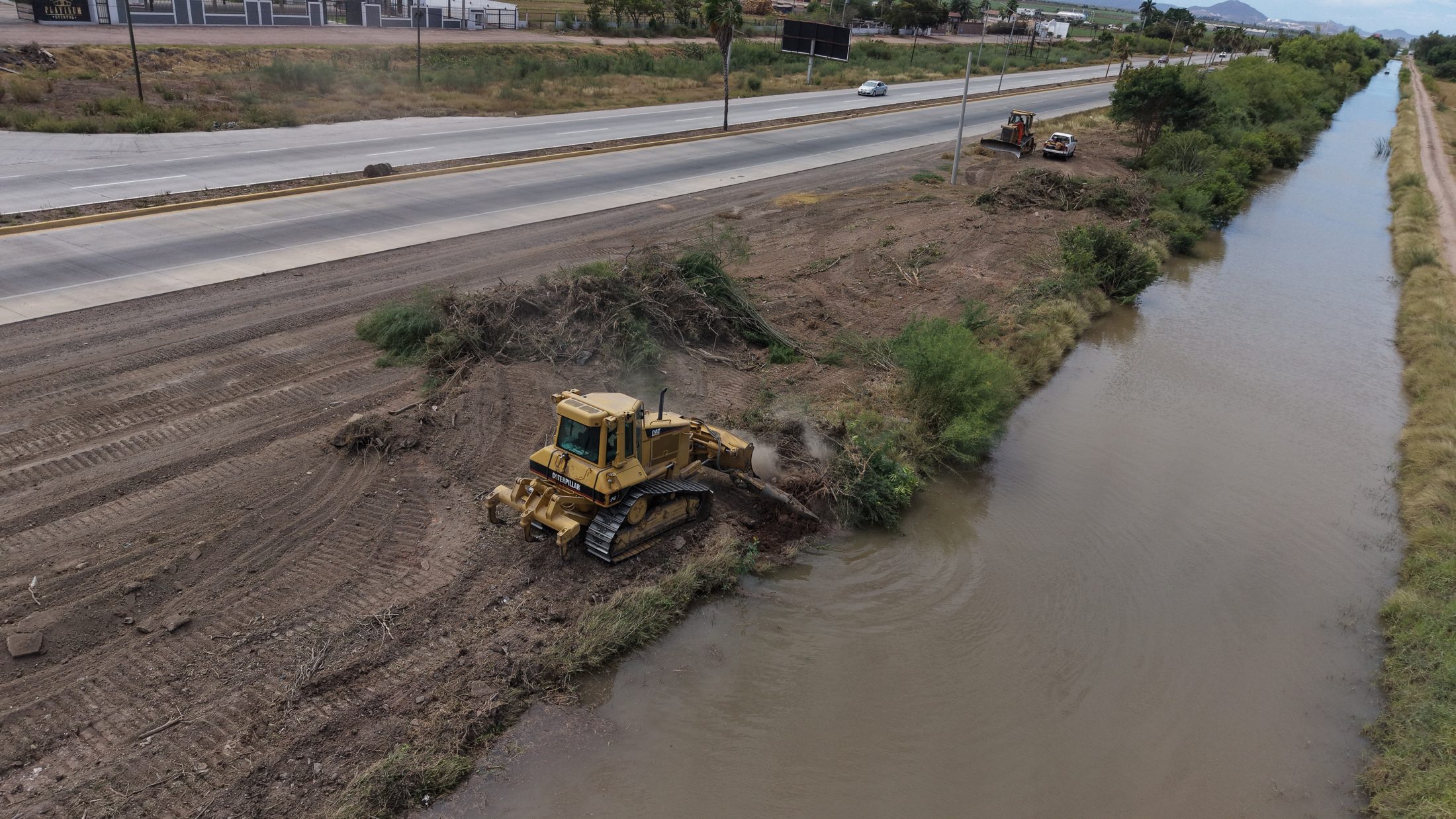 Bulldozer trabajando el bordo de un canal junto a infraestructura vial, 6 de mayo de 2026.