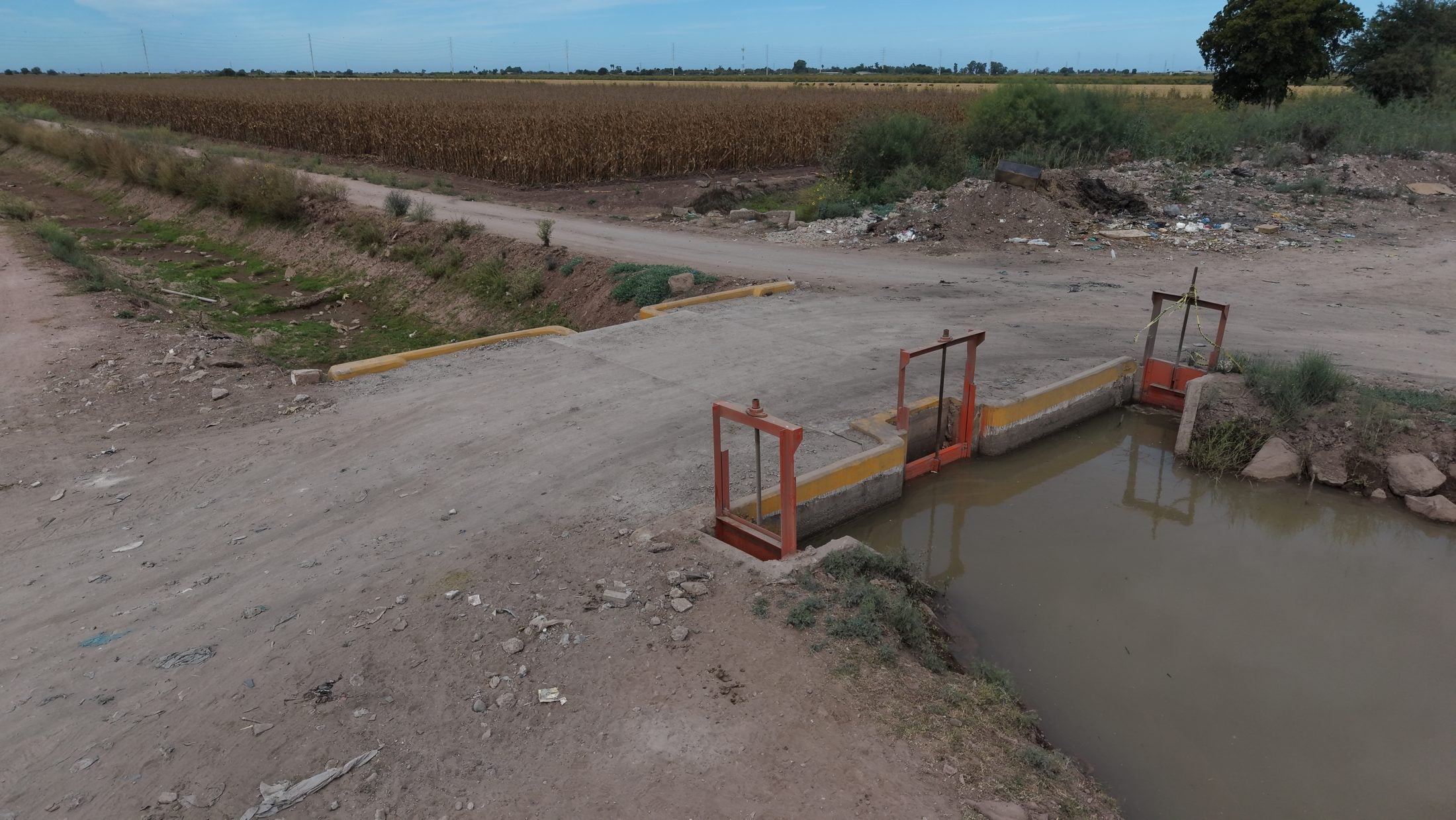 Estructura de control en operación. Vista aérea de una compuerta y su cruce de servicio sobre la red hidráulica.